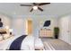 A staged main bedroom has a bed with a blue throw, dresser, wall art, and a plant at 1406 Windy Ridge Se Ct, Conyers, GA 30013