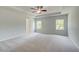 Spacious bedroom featuring a ceiling fan, tray ceiling, and two bright windows at 19 Camellia Dr, Fairburn, GA 30213