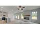 Open-concept living area featuring a modern fireplace, wood mantle, and seamless flow to the kitchen at 19 Camellia Dr, Fairburn, GA 30213