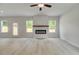 Bright living area featuring a modern fireplace with a wooden mantel and seamless access to the backyard at 19 Camellia Dr, Fairburn, GA 30213