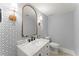 Stylish powder room with patterned wallpaper and gold fixtures at 311 Rolling Rock Se Rd, Marietta, GA 30067