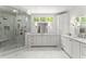 Spa-like bathroom features dual sinks, marble tile, and glass-enclosed shower with multiple shower heads at 311 Rolling Rock Se Rd, Marietta, GA 30067