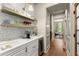 Well-appointed butler's pantry with open shelving, granite countertop, and storage at 311 Rolling Rock Se Rd, Marietta, GA 30067