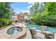 Back exterior view showcasing the home's pool, stone spa, and outdoor lounge area at 311 Rolling Rock Se Rd, Marietta, GA 30067