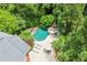 Aerial view of the backyard pool, patio and fireplace surrounded by lush landscaping at 311 Rolling Rock Se Rd, Marietta, GA 30067