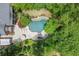 Aerial view of a pristine pool, hot tub, patio, and ample seating among serene landscaping at 311 Rolling Rock Se Rd, Marietta, GA 30067