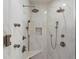 Luxurious shower boasts marble tile, bench and multiple shower heads for a spa experience at 311 Rolling Rock Se Rd, Marietta, GA 30067