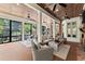 Relaxing sunroom with fireplace, ceiling fans, and views of wooded backyard at 311 Rolling Rock Se Rd, Marietta, GA 30067