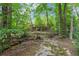 Lush backyard featuring a walking bridge, creek, and foot path at 311 Rolling Rock Se Rd, Marietta, GA 30067