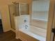 Bathroom featuring a tub with glass shower doors and a bright window at 519 Granite Nw Ct, Lawrenceville, GA 30044