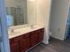 Bright bathroom featuring a double sink vanity with cherry wood cabinetry and walk-in shower at 519 Granite Nw Ct, Lawrenceville, GA 30044