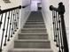 Carpeted staircase with dark metal railings and white trim leading to the upper level at 519 Granite Nw Ct, Lawrenceville, GA 30044