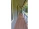 Long covered porch with wood flooring and white railings at 61 Maxie Ln, Dallas, GA 30157