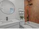 Modern bathroom featuring a sleek vanity, round mirror, and stylish wood-look tile at 2809 Glenwood Se Ave, Atlanta, GA 30317