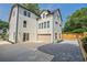 A modern white two-story home features a two-car garage and lush, well-maintained landscaping at 2809 Glenwood Se Ave, Atlanta, GA 30317