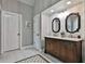 Bathroom with wooden cabinets, double sinks and white marble floors and walls at 160 Isleworth Way, Fayetteville, GA 30215