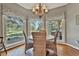 Bright breakfast nook featuring a round table, wicker chairs, and large windows overlooking the scenic outdoors at 160 Isleworth Way, Fayetteville, GA 30215