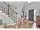 This bright foyer features hardwood floors, a staircase with white railings, and a dark front door at 160 Isleworth Way, Fayetteville, GA 30215