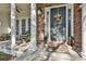 Inviting front porch with stone accents, stately columns and seating area at 160 Isleworth Way, Fayetteville, GA 30215