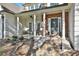 Inviting front porch with stone accents, stately columns and seating area at 160 Isleworth Way, Fayetteville, GA 30215