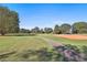 Scenic view of a lush green golf course with mature trees in the background on a sunny day at 160 Isleworth Way, Fayetteville, GA 30215