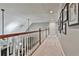 Hallway featuring plush carpet, wooden banister and framed pictures on the wall at 160 Isleworth Way, Fayetteville, GA 30215