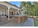 Outdoor bar featuring stone accents and seating for seven overlooks the spacious backyard and covered patio at 160 Isleworth Way, Fayetteville, GA 30215