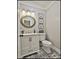 Stylish powder room featuring modern fixtures, elegant mirror and decorative tile flooring at 160 Isleworth Way, Fayetteville, GA 30215