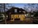 Open-air patio with an outdoor kitchen and bar area, set against a backdrop of lush trees and twilight sky at 160 Isleworth Way, Fayetteville, GA 30215