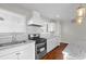 Bright kitchen featuring granite countertops, a stylish hood, and stainless steel appliances at 2677 Tilson Rd, Decatur, GA 30032