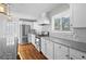 A well-lit kitchen boasts a stainless steel refrigerator, sleek white cabinetry, herringbone backsplash, and granite countertops at 2677 Tilson Rd, Decatur, GA 30032