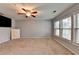 Spacious carpeted room with a ceiling fan and three large windows at 3351 Vintage Se Cir, Smyrna, GA 30080