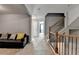 Hallway featuring stairs with wrought iron spindles and a comfortable black leather sofa with accent pillows at 3351 Vintage Se Cir, Smyrna, GA 30080