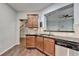 Charming kitchen featuring wood cabinets, stainless dishwasher, and views into the living space at 3351 Vintage Se Cir, Smyrna, GA 30080