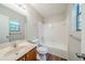 Bright bathroom with white tiled shower-tub, window, and vanity with a neutral countertop at 1934 Patton Pl, Lithonia, GA 30058