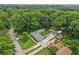 An aerial view of the property showcases the beautiful grounds, multiple structures, and tree coverage at 2624 Lake Erin Drive Dr, Tucker, GA 30084