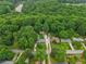 An aerial view shows the well-manicured lot, multiple structures, and lush green forest surrounding the property at 2624 Lake Erin Drive Dr, Tucker, GA 30084