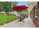 Inviting back porch features brick accents and an outdoor dining set under a bright red umbrella at 2624 Lake Erin Drive Dr, Tucker, GA 30084
