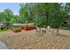 Landscaped backyard with garden beds, exterior buildings, and chairs, perfect for outdoor relaxation at 2624 Lake Erin Drive Dr, Tucker, GA 30084
