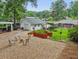 A pea gravel area is surrounded by a garden and leads to a detached garage and the back of the house at 2624 Lake Erin Drive Dr, Tucker, GA 30084