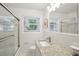 Bright, white bathroom features a vanity with granite countertop and a shower with glass door at 2624 Lake Erin Drive Dr, Tucker, GA 30084