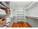 Bright walk-in closet with custom white shelving, hanging rods, and neatly arranged storage baskets at 2624 Lake Erin Drive Dr, Tucker, GA 30084