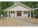 Exterior view of the white building with red doors, surrounded by lush greenery at 2624 Lake Erin Drive Dr, Tucker, GA 30084