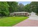 Beautiful red brick home with a lush lawn, mature trees, and a detached two car garage at 2624 Lake Erin Drive Dr, Tucker, GA 30084