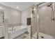 Bright bathroom features a tub and separate tiled shower with glass door at 416 Montclair Ct, Woodstock, GA 30188