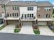 View of the townhome exteriors and attached garages with driveway at 416 Montclair Ct, Woodstock, GA 30188