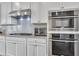 A kitchen featuring white cabinets, stainless steel appliances, gas cooktop, and double ovens at 416 Montclair Ct, Woodstock, GA 30188