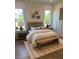 Well-lit bedroom features two windows, decorative pillows, bench and accent rug at 6930 Pond View Dr, Cumming, GA 30028