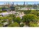 Aerial view features neighborhood, mature trees, and city skyline at 819 Belgrade Ne Ave, Atlanta, GA 30306