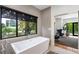 Luxurious bathroom featuring a freestanding bathtub with large window and view to the main bedroom at 819 Belgrade Ne Ave, Atlanta, GA 30306